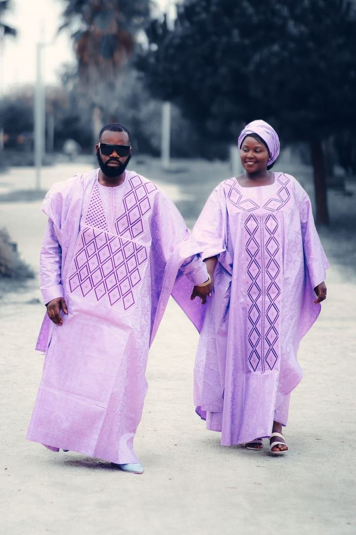 Un couple en tenues traditionnelles lilas marchant ensemble